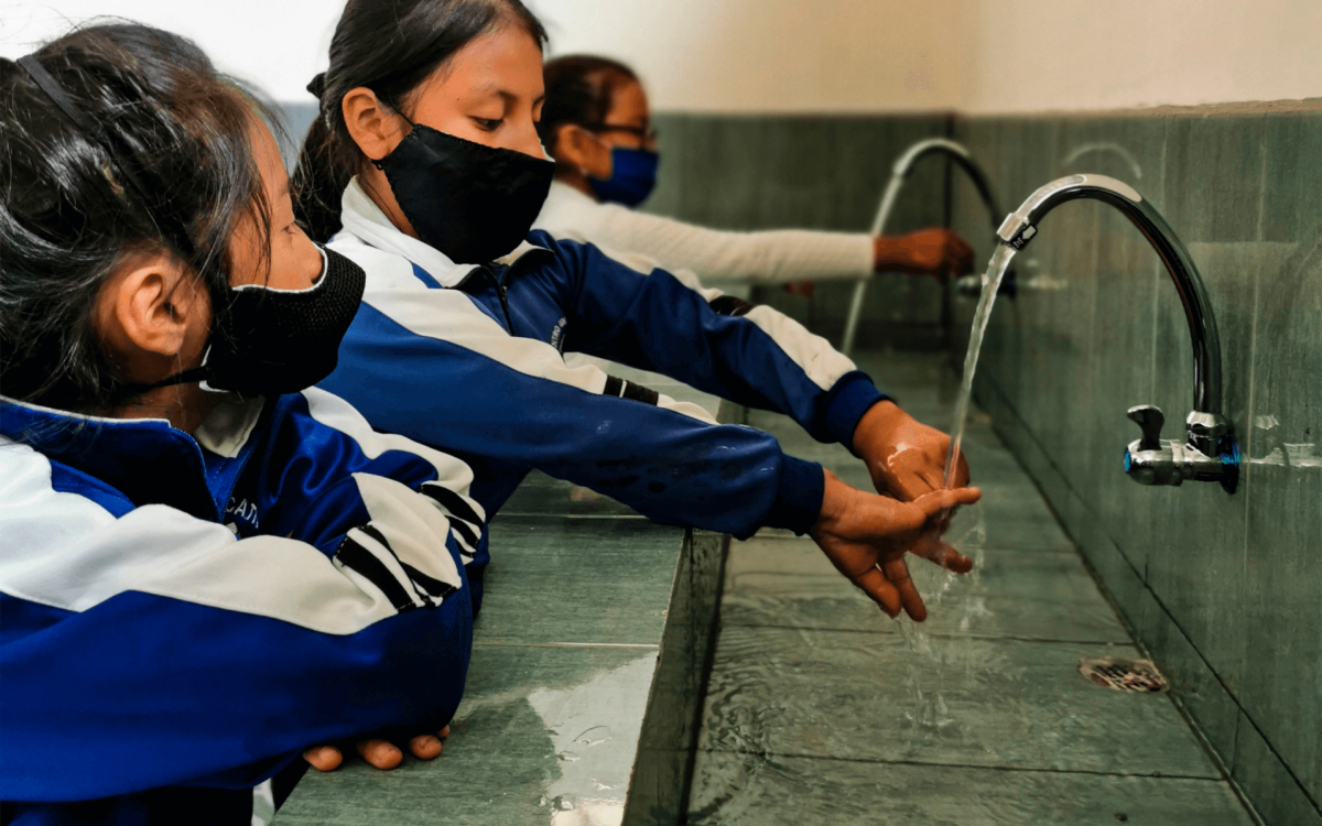 children washing hands with masks on