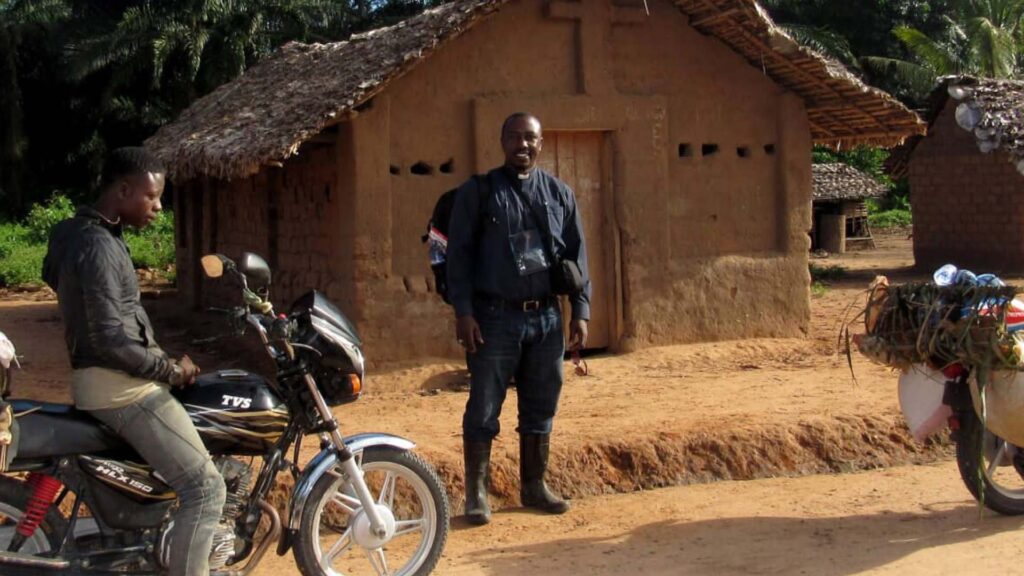 a man standing in front of a small church